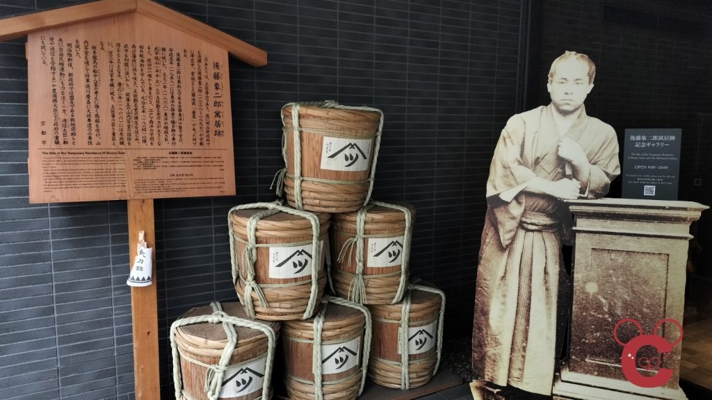 京都市中京区にある後藤象二郎寓居跡（壺屋）の入り口の写真。後藤象二郎の大きな肖像写真パネルや、寓居跡の説明看板が並んでいる。中岡慎太郎ランドの現地レポート用画像。