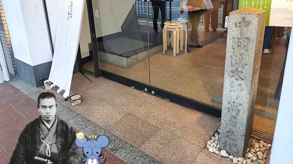 京都にある幕末・土佐藩の志士、中岡慎太郎の寓居跡を紹介する画像。右側には抹茶カフェの入り口に建つ「中岡慎太郎 寓居之地」の石碑写真、左側には中岡慎太郎の肖像写真とネズミのキャラクター「ちゅう乃」が並んだデザイン。中岡慎太郎ランドの記事用画像。