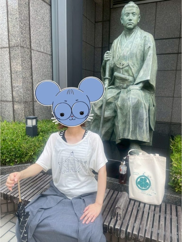 ホテルオークラ京都の桂小五郎像前で、像と同じ座り姿で記念撮影する観光客