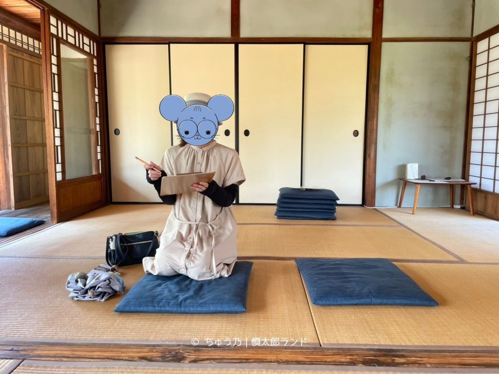 岩倉具視幽棲旧宅の主屋座敷でガイドの説明を聞く様子