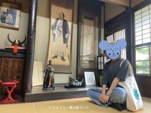 京都・伏見の寺田屋「龍馬の部屋」で、坂本龍馬の展示を前に座る筆者