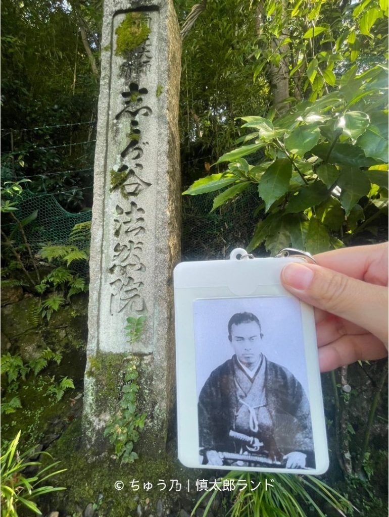 京都・法然院の入口に立つ「法然院」の石碑と、手に持った中岡慎太郎の写真入りキーホルダー。