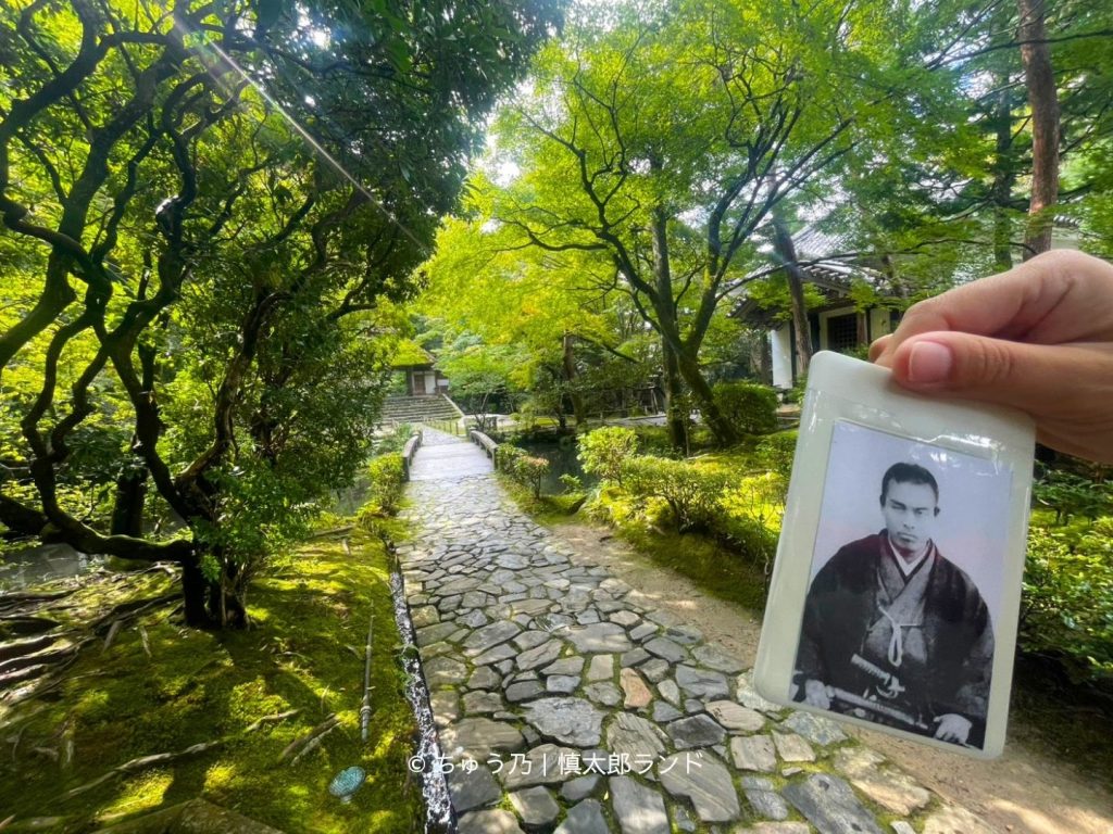 京都・法然院の境内に続く石畳の道と苔の庭園。手前には中岡慎太郎の写真入りキーホルダー。