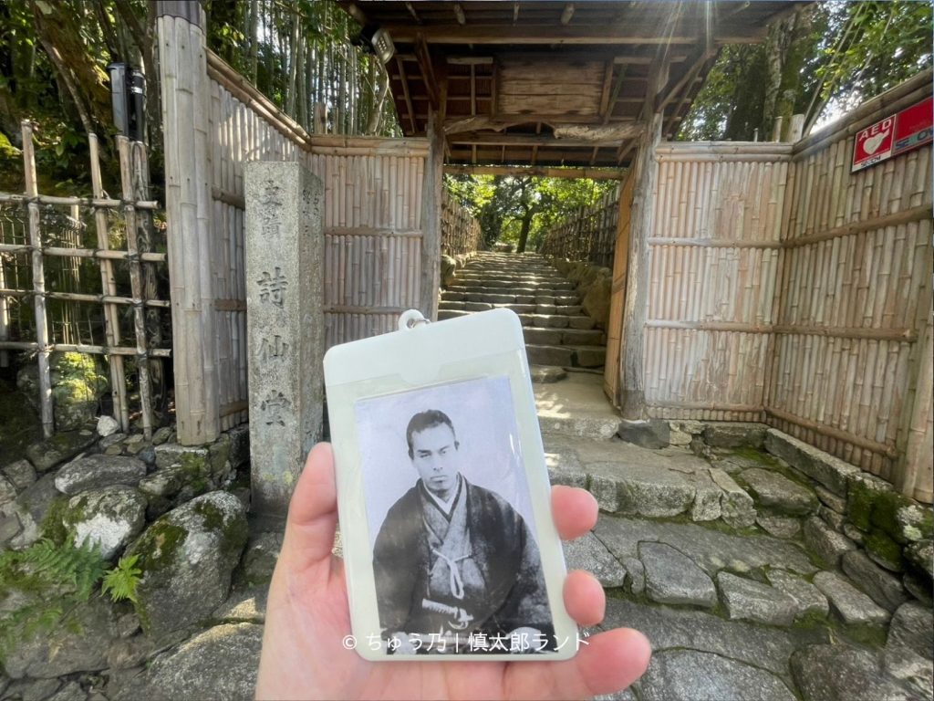 京都・詩仙堂の竹垣に囲まれた入口と石段。手前には中岡慎太郎の写真入りキーホルダー。